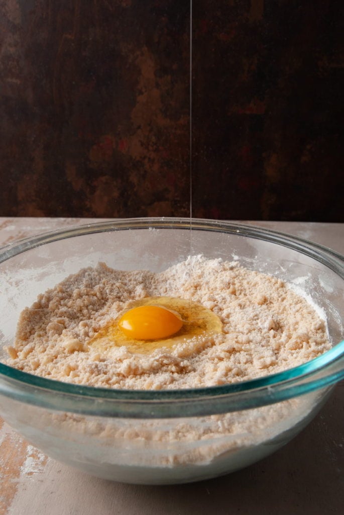 cracking egg into cookie cake dough