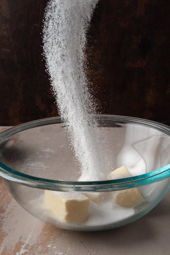 adding sugar to mixi9ng bowl with unsalted butter
