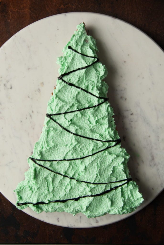 adding christmas tree string light decoration to christmas cookie cake