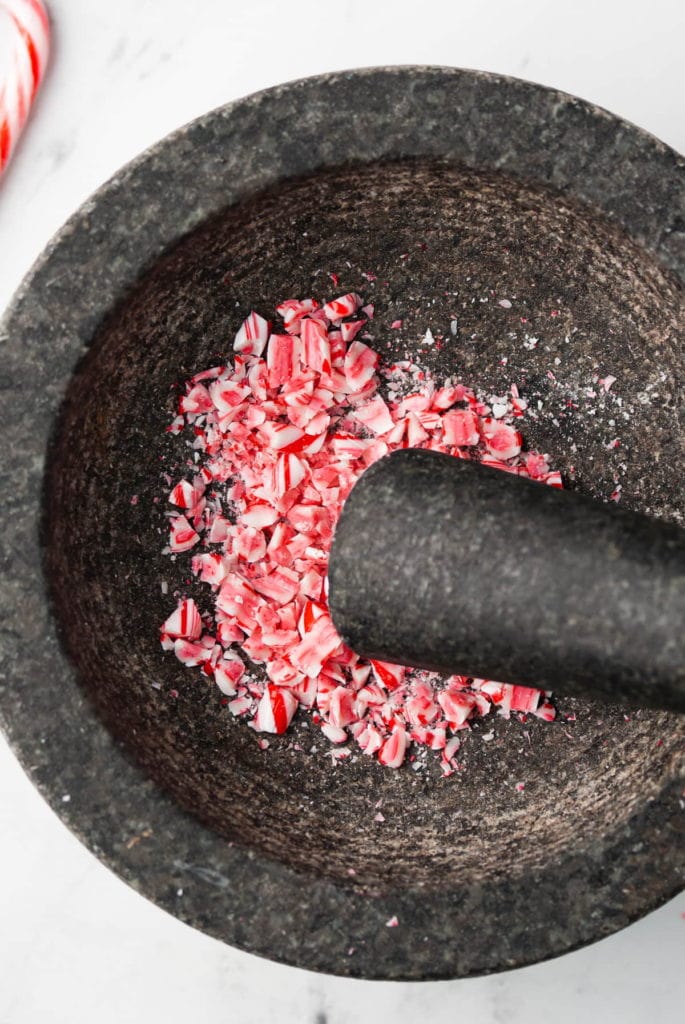 using a pestal and mortar to crush candy canes