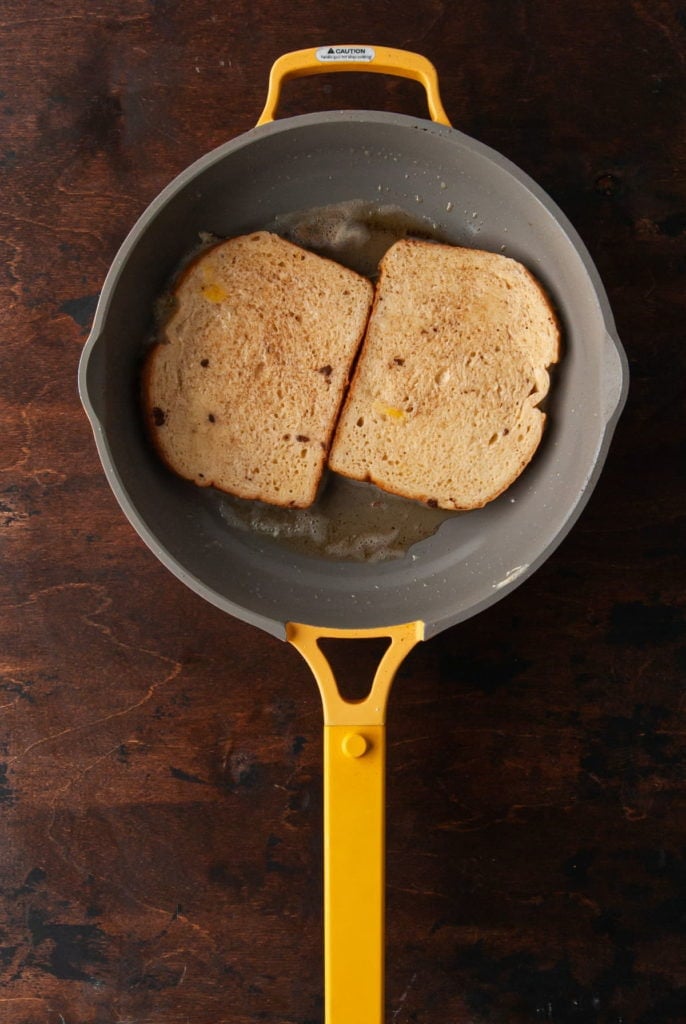 2 slices of sourdough bread with egg wash frying in butter