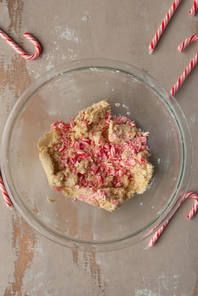adding crushed candy cane to shortbread cookie dough