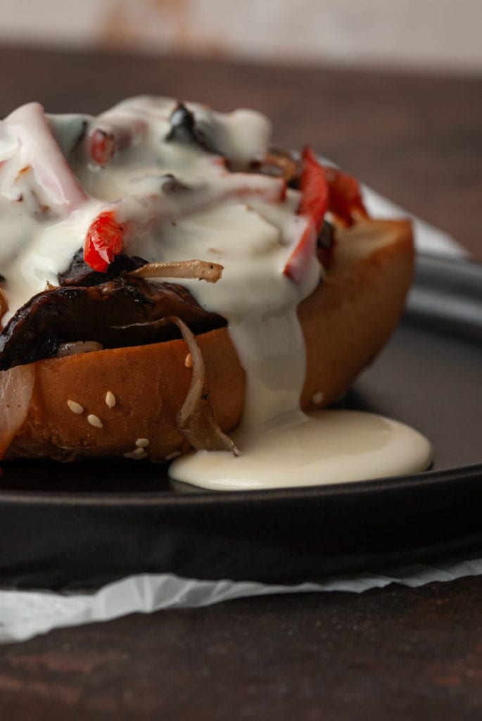 closeup of cheese sauce dripping out of portobello cheesesteak