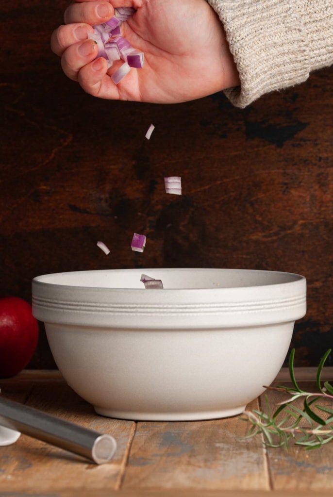Dropping Diced Red Onion into a Large Mixing Bowl
