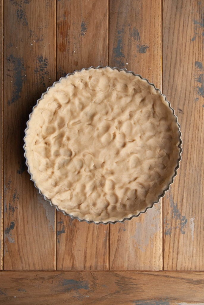 quiche crust with marks from pressing it into the quiche pan