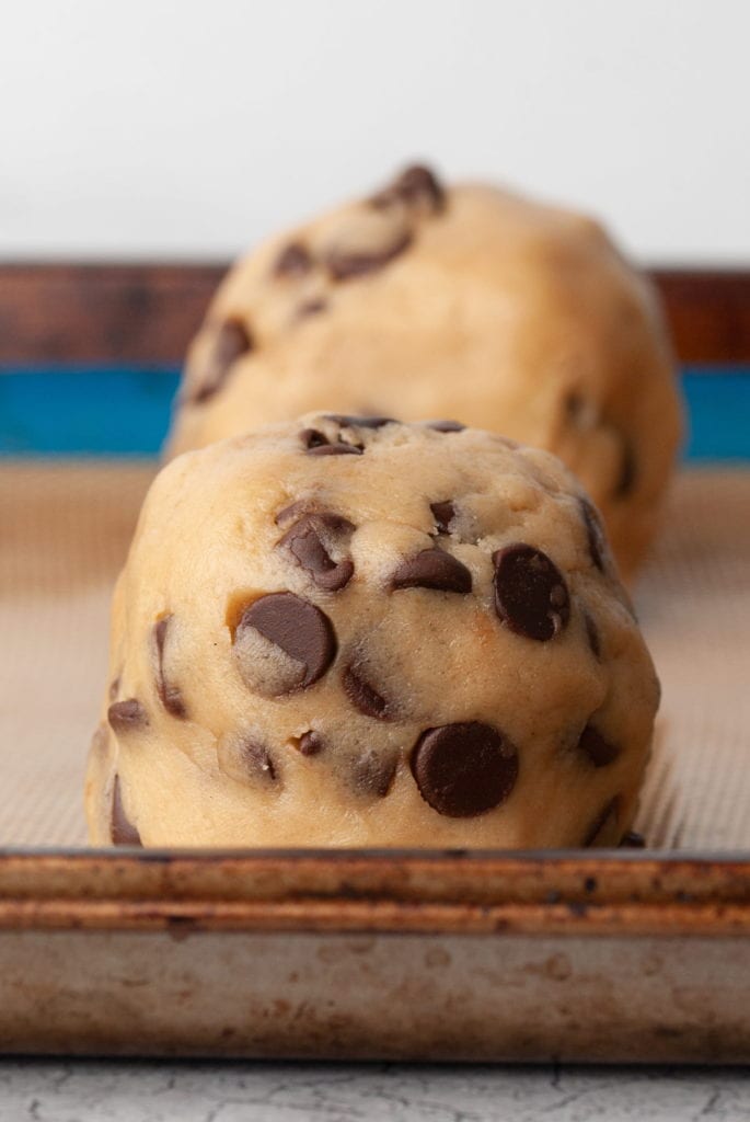 close up of a Gideons bakehouse cookie copycat cookie dough ball on a lined baking sheet