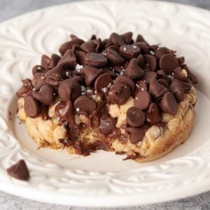 white decorative plate with massive chocolate chip cookie with bite taken out of it