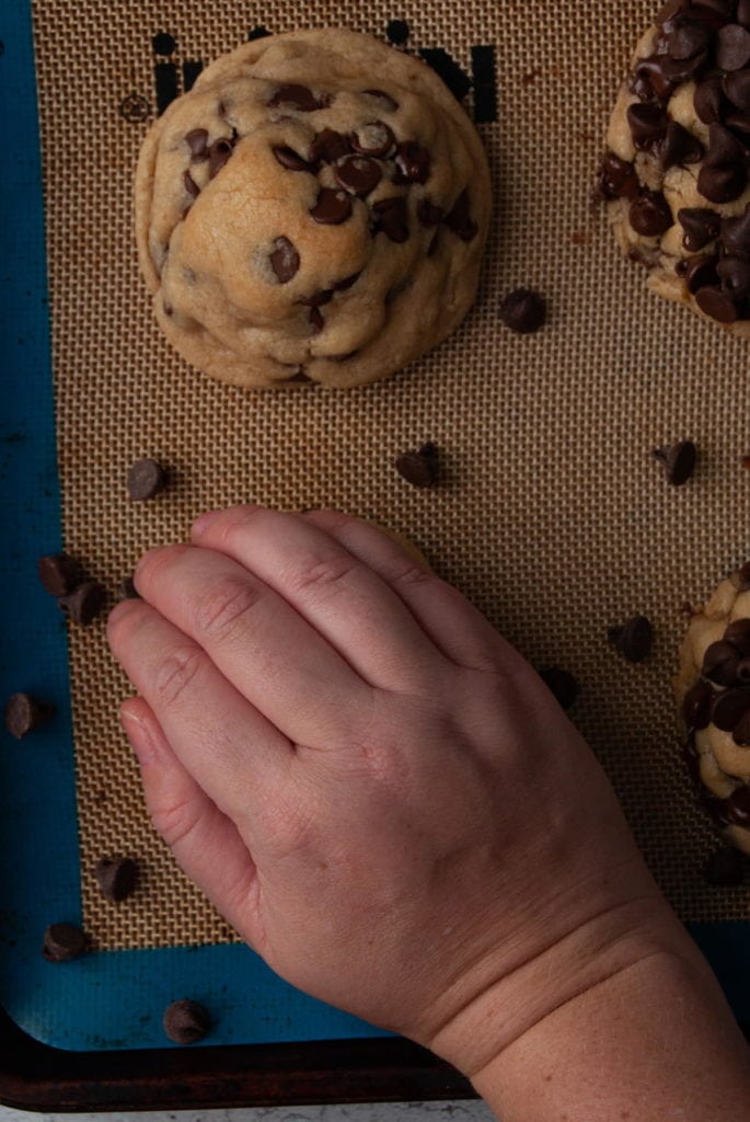 pressing a handful of chocolate chips into the top of a baked cookie