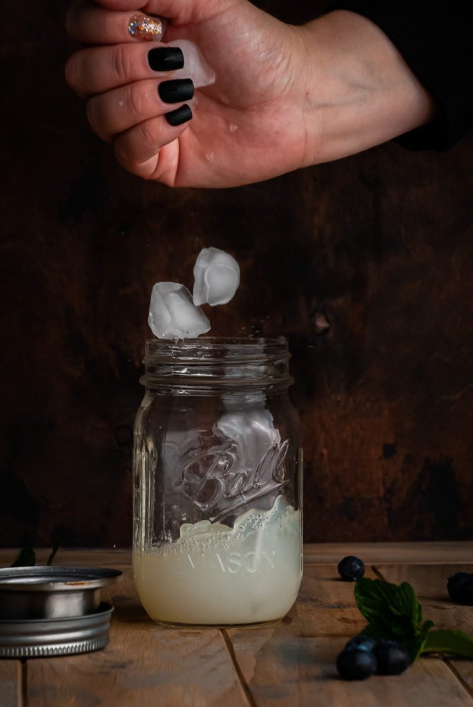 dropping ice into cocktail shaker