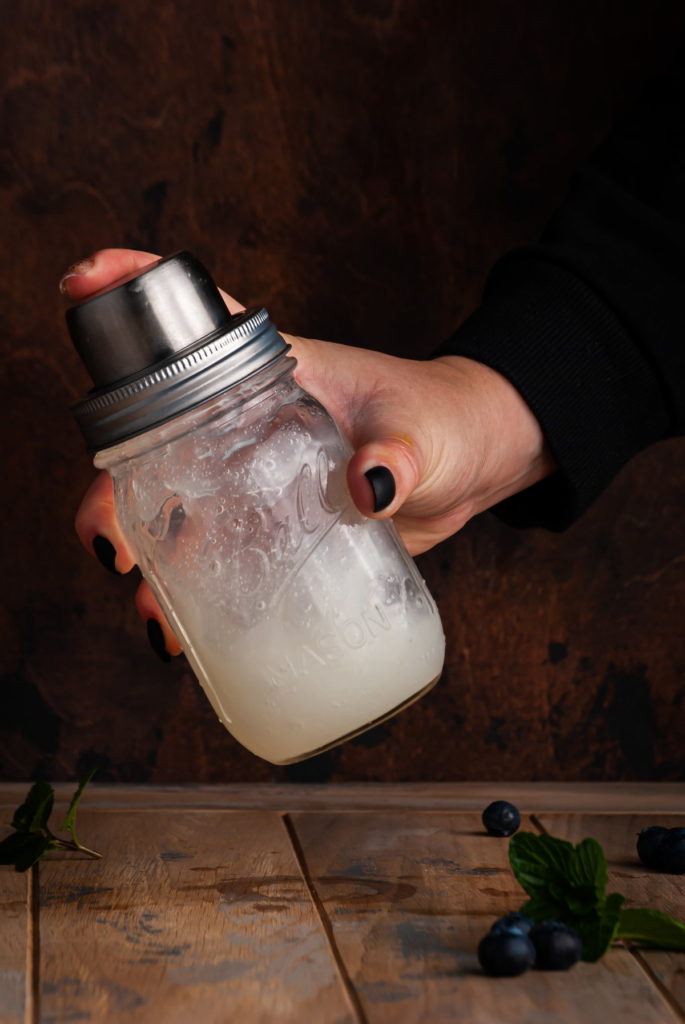 shaking a gin cocktail in a cocktail shaker