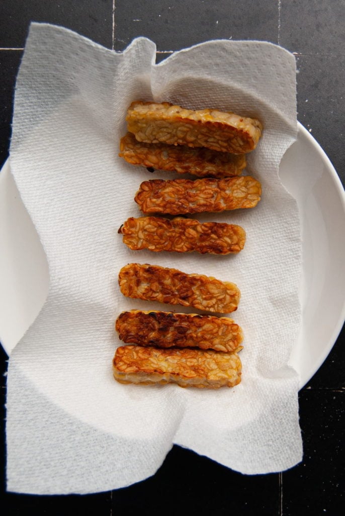 placing tempeh on paper towel to soak up excess oil