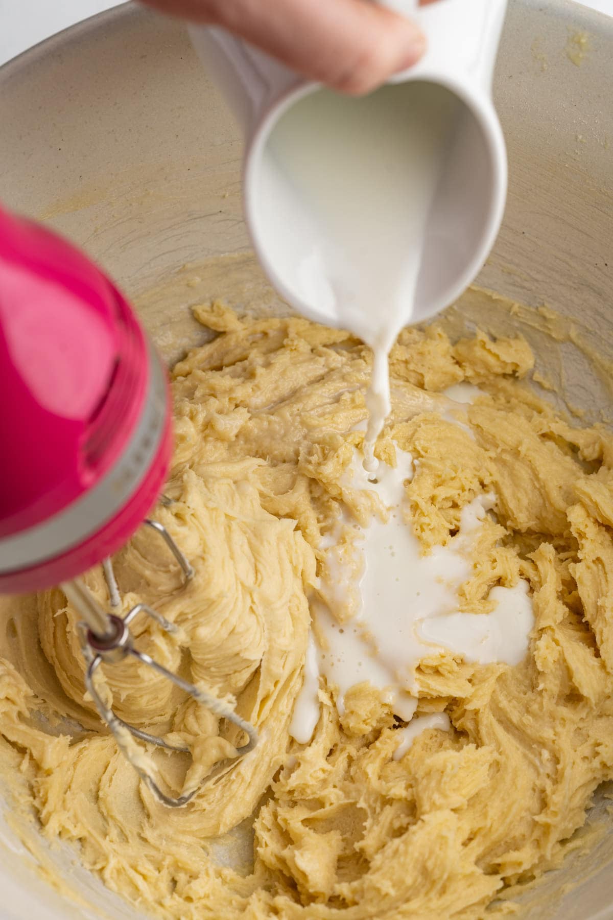 Adding milk to loaf cake batter while hand mixer is on