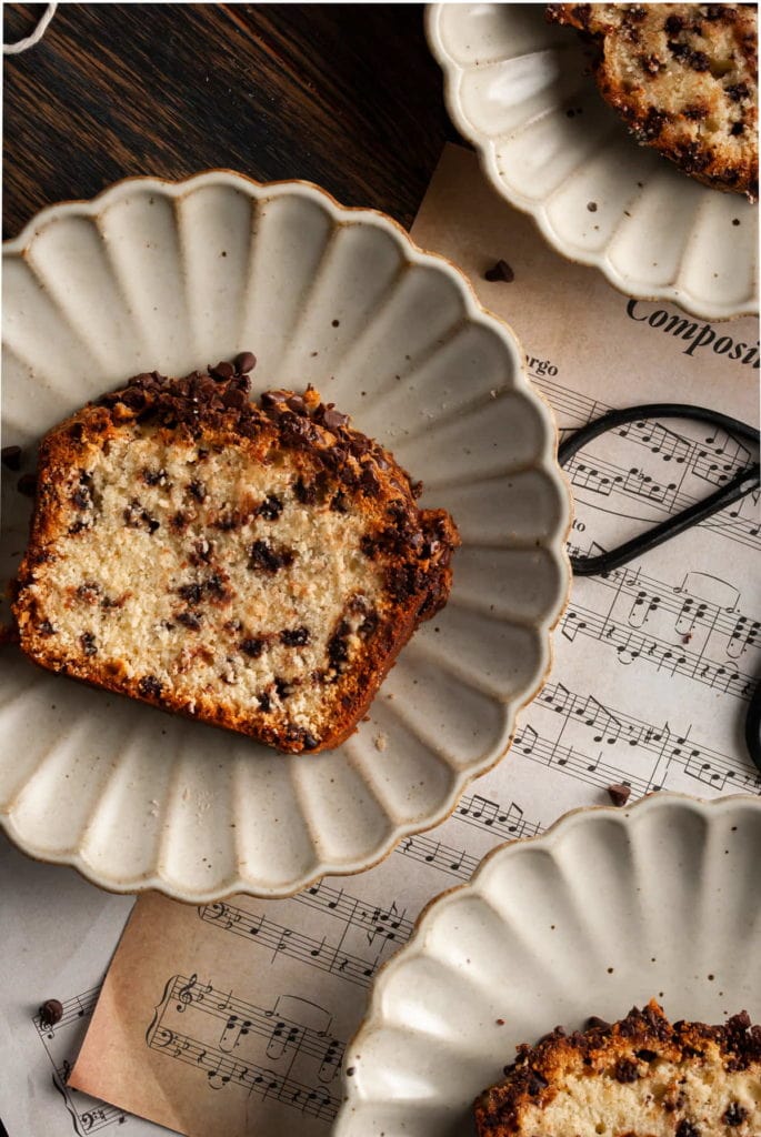 scalloped plate with a slice of chocolate chip loaf