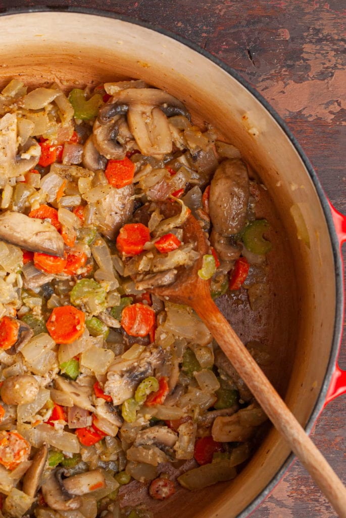 close up of making roux with olive oil and flour with veggies