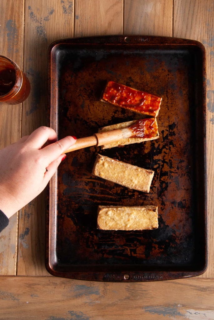 brushing bbq sauce on tofu