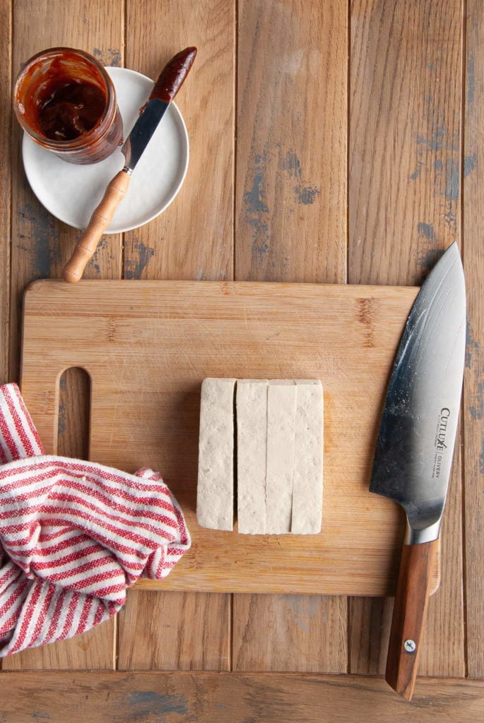 slicing a block of tofu into 4 parts