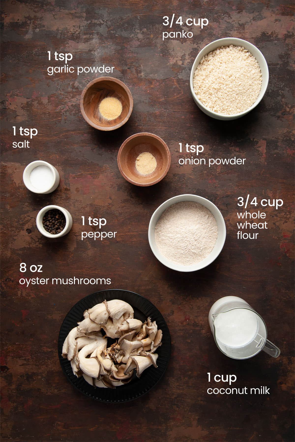 Everything you need to make breaded oyster mushrooms including whole wheat flour, onion powder, garlic powder, salt, pepper, coconut milk, panko breadcrumbs, and oyster mushrooms.