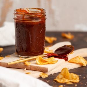 jar of homemade vegan bbq sauce with some on a spoon