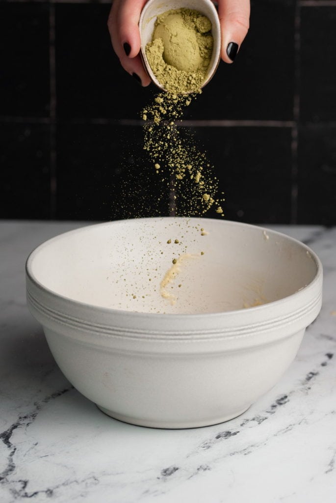 Adding matcha powder to other half of brownie batter.