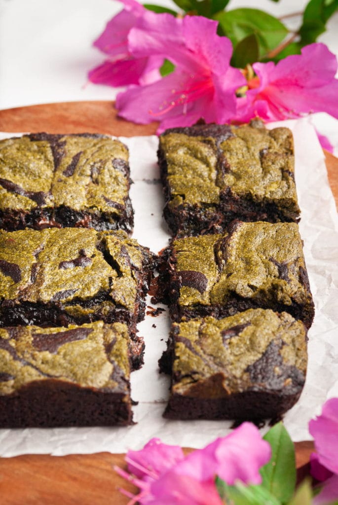 fudgy baked matcha brownies lined up on parchment paper