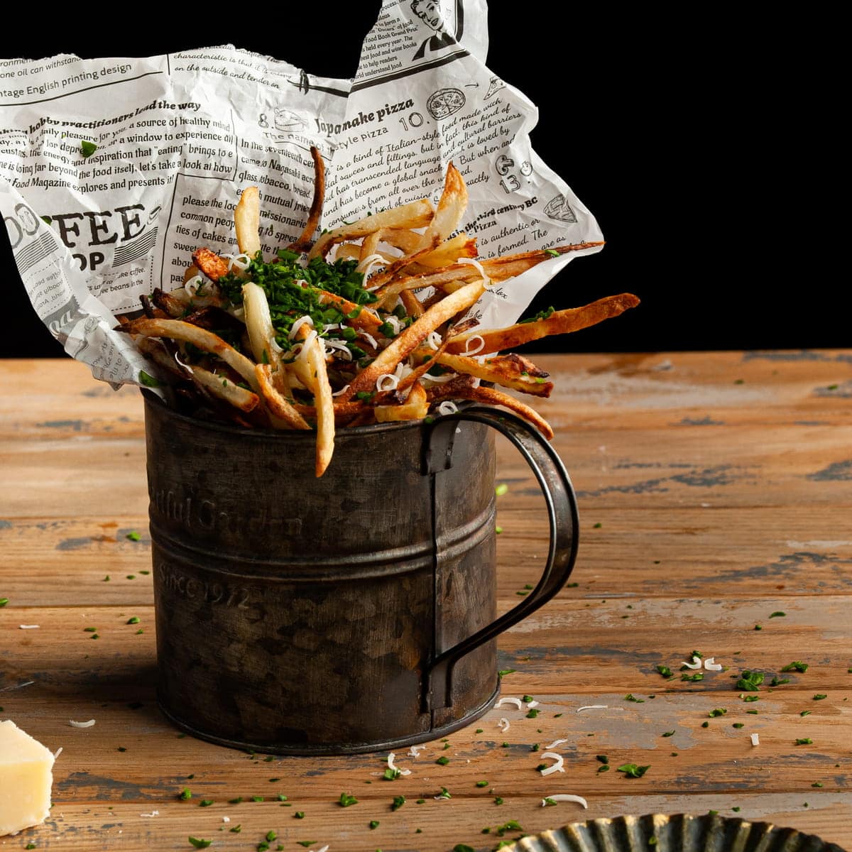 galvanized mug full od homemade truffle french fries garnished with parmesan and parsley