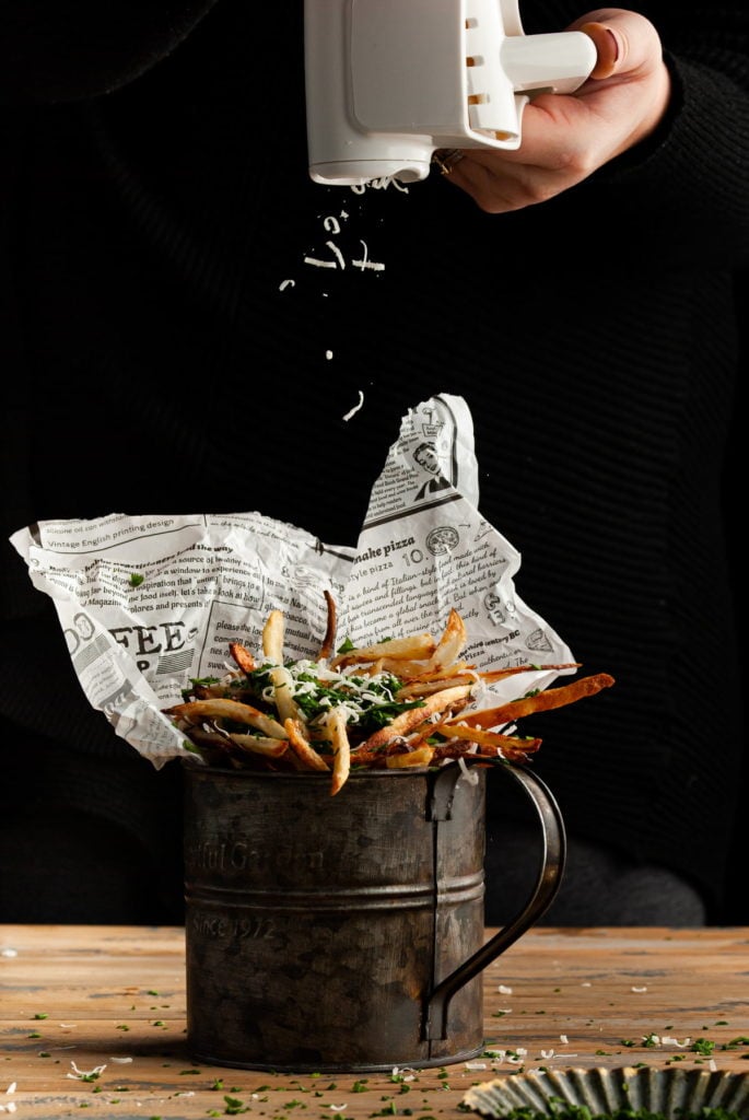 adding freshly grated parmesan to your parmesan truffle fries