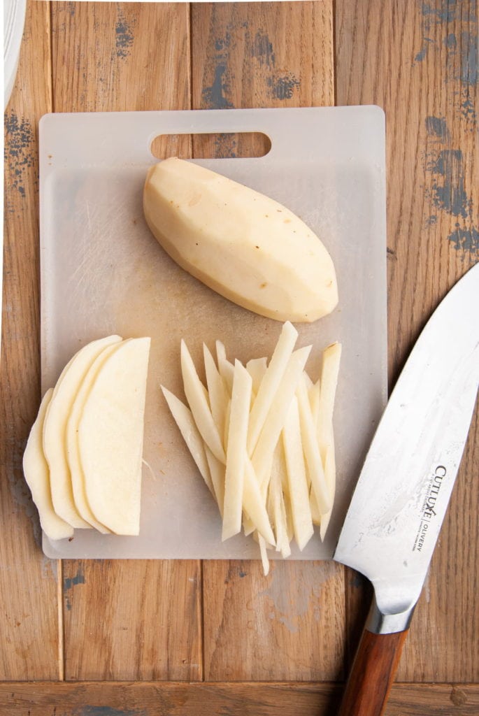 Cutting sliced potato into shoestring fries.
