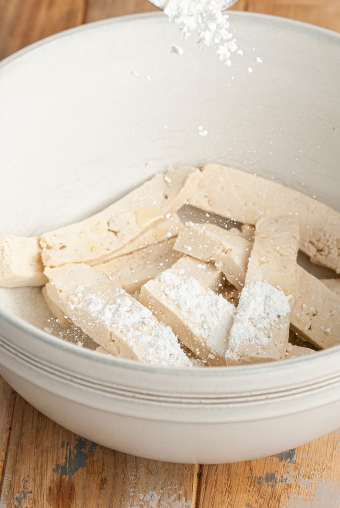 tossing tofu in cornstarch