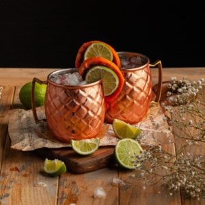 two copper mugs with aperol gin cocktail