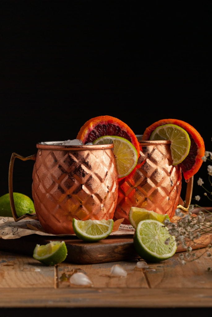 two sweaty copper mugs garnished with lime and blood orange