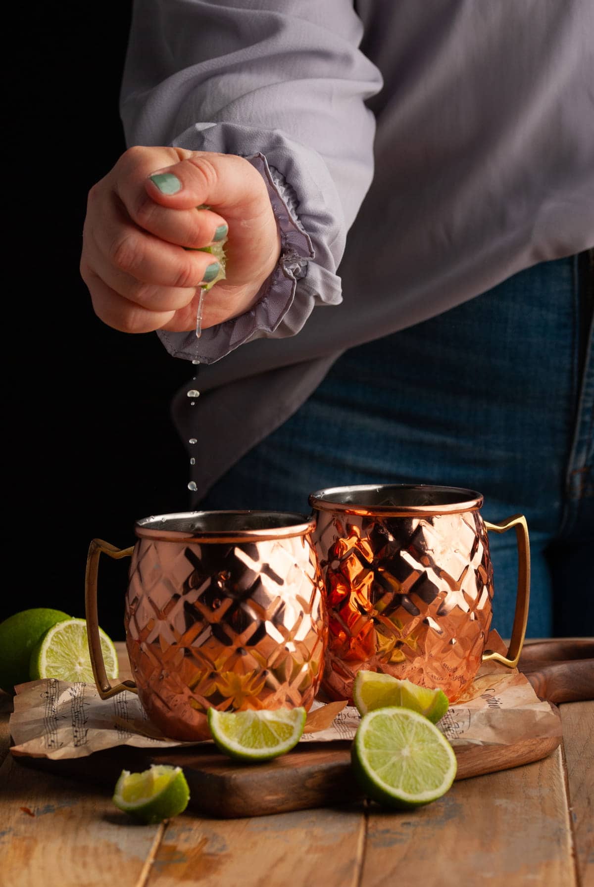 squeezing juice of a lime into a copper mug