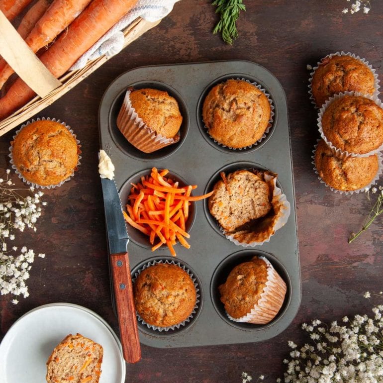 overhead shot of muffin tin filled with carrots and banana carrot muffins