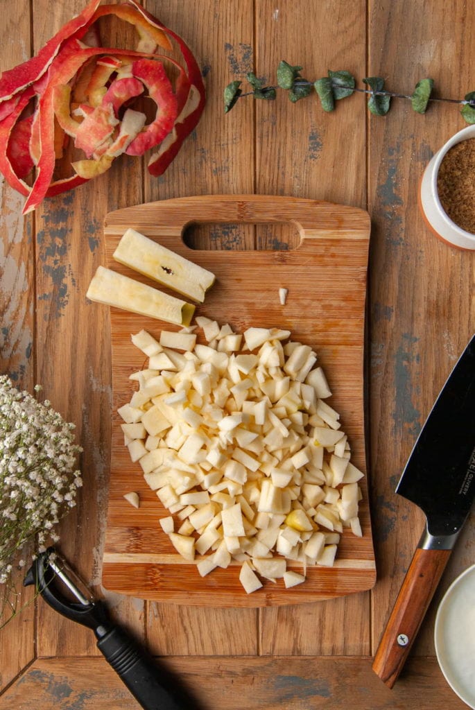 Cutting around two apple cores and dicing the apples into small chunks.