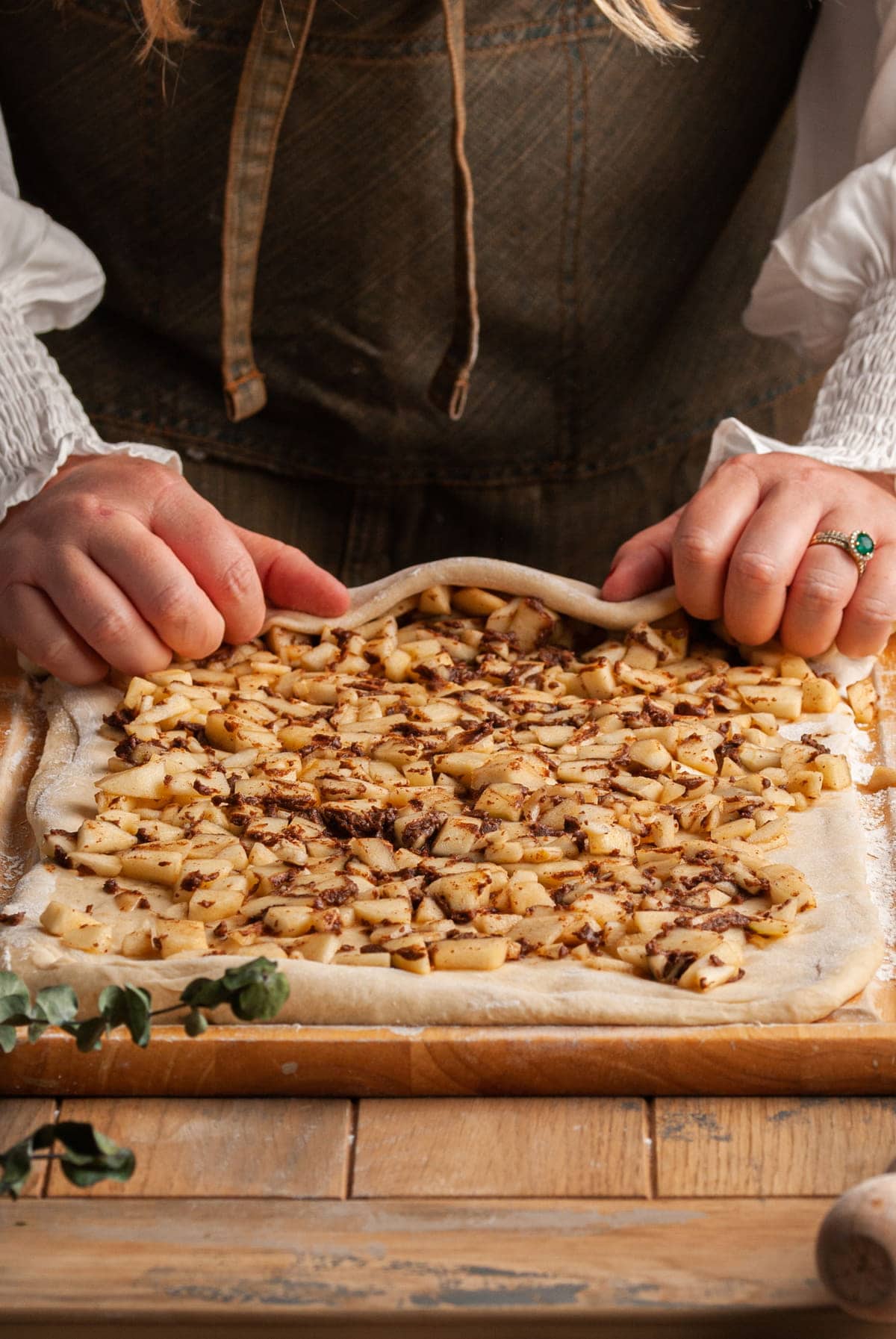 using two hands to roll up cinnamon rolls