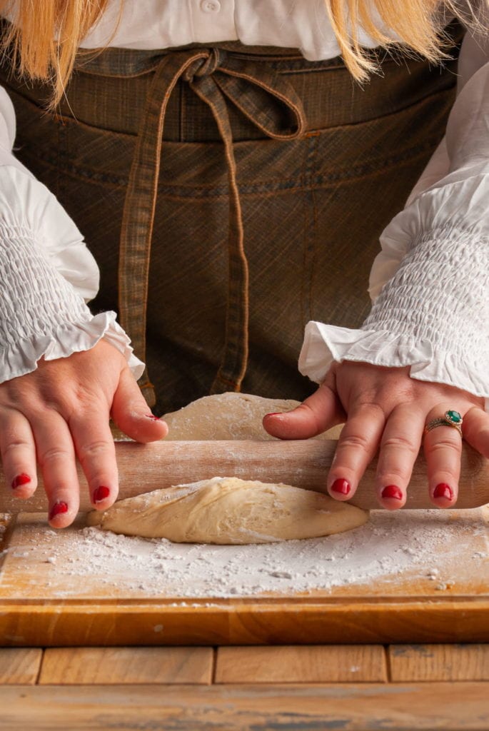 Using a rolling pin to roll out cinnamon roll dough