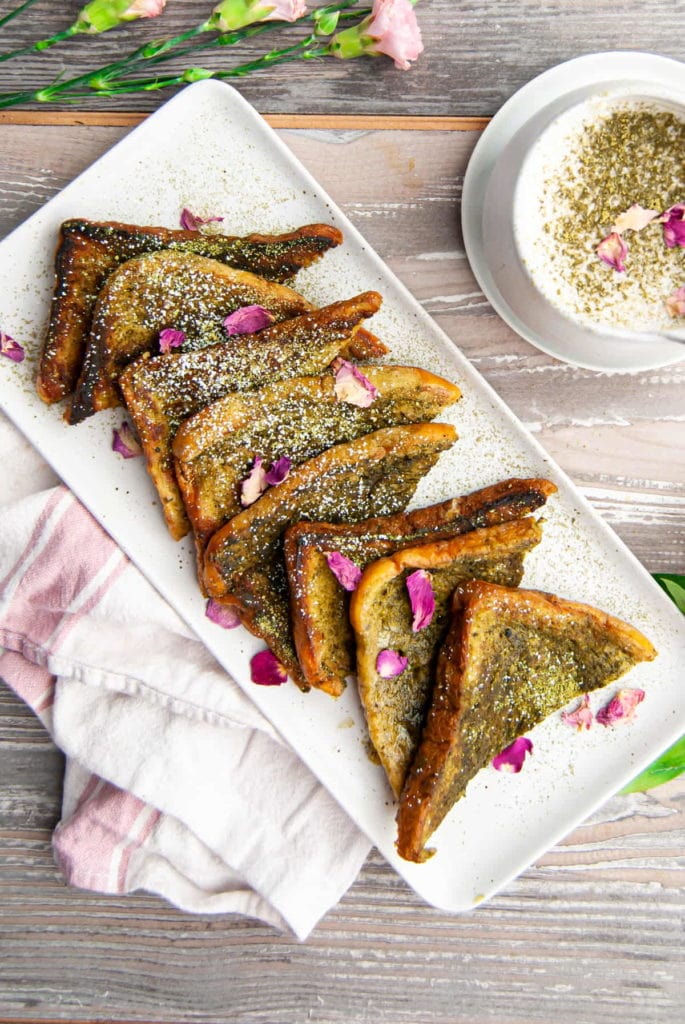 overhead shot of slices of matcha french toast garnished with edible rose petals