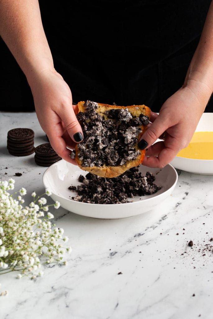 coating brioche bread with egg wash with crushed oreos