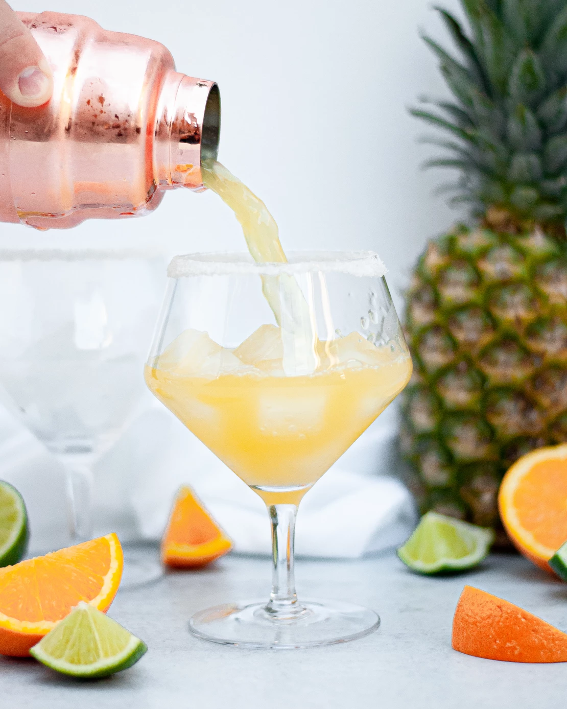 skinny pineapple margarita being poured into a glass