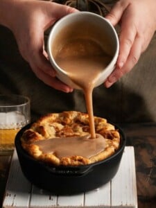 pouring bourbon sauce over bread pudding