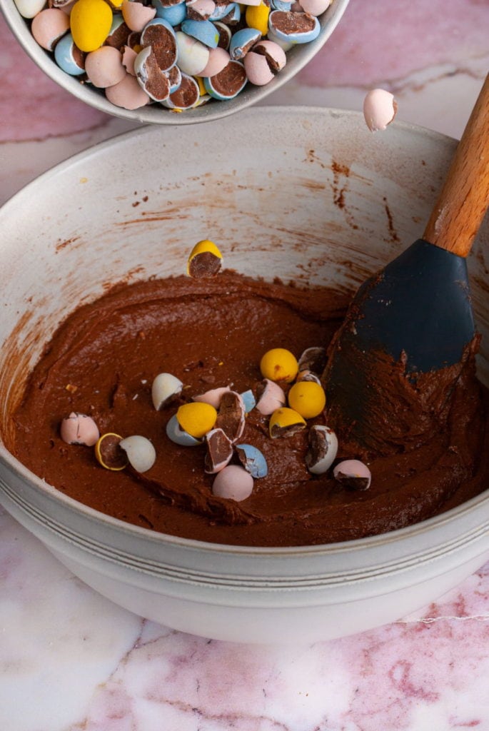 Folding half of the crushed cadbury mini eggs into the brownie batter