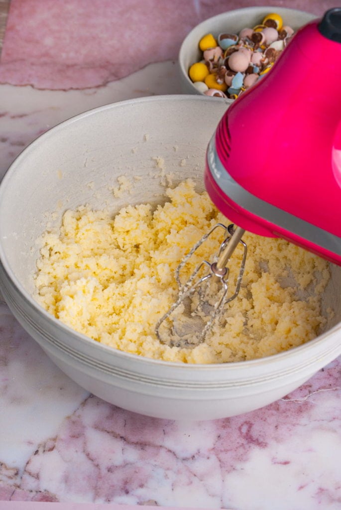 Using a hand mixer to cream butter and sugar together for brownie batter