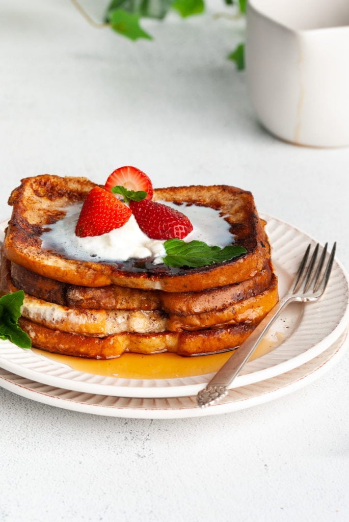 close up cropped image of stack of egg white french toast with a plant in the background
