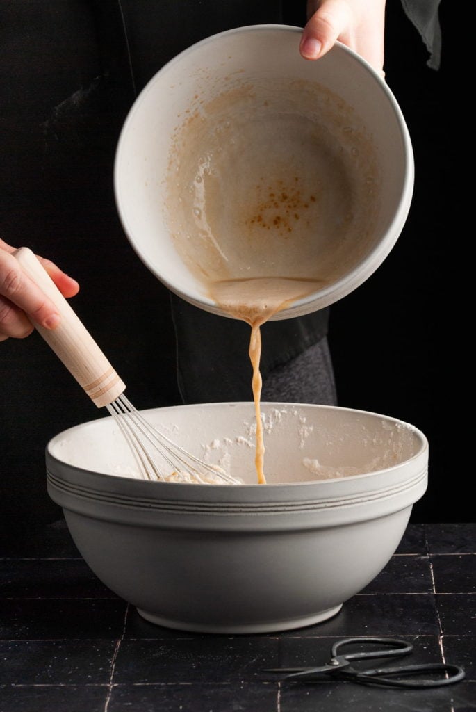 adding activated yeast mixture to cinnamon roll dough ingredients