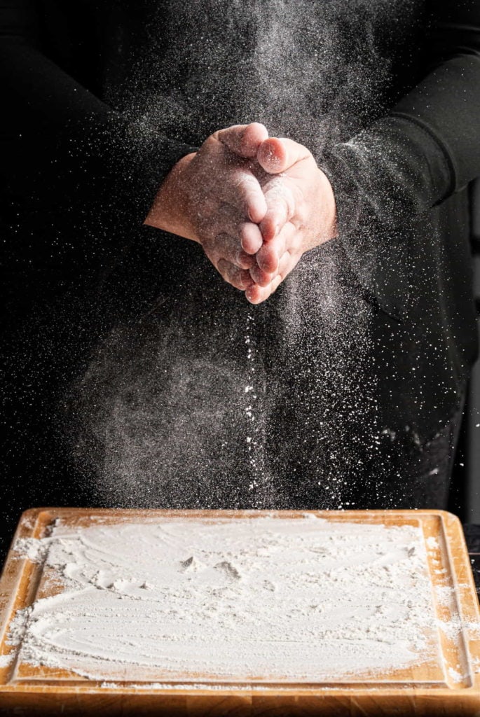 flouring hands to prepare for kneading sticky dough