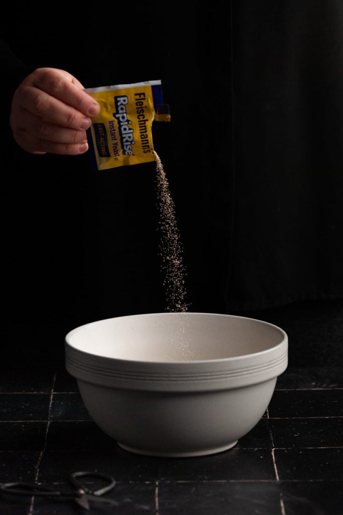 adding instant yeast to a mixing bowl