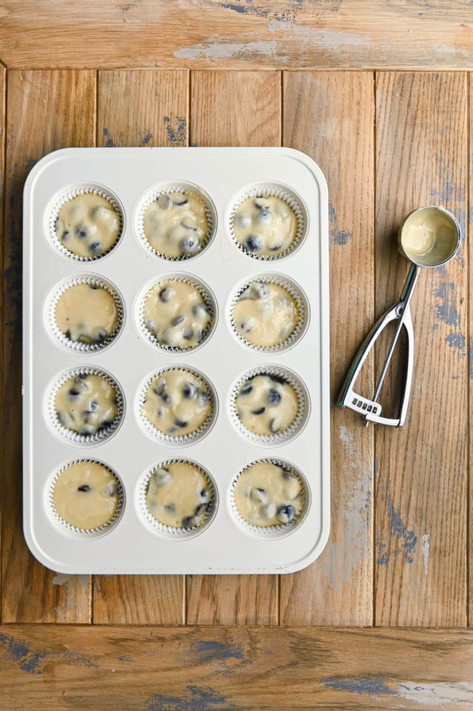 adding batter to lined muffin tin