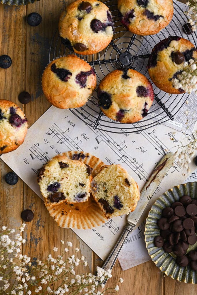 flat lay of blueberry chocolate chip muffins with one split open