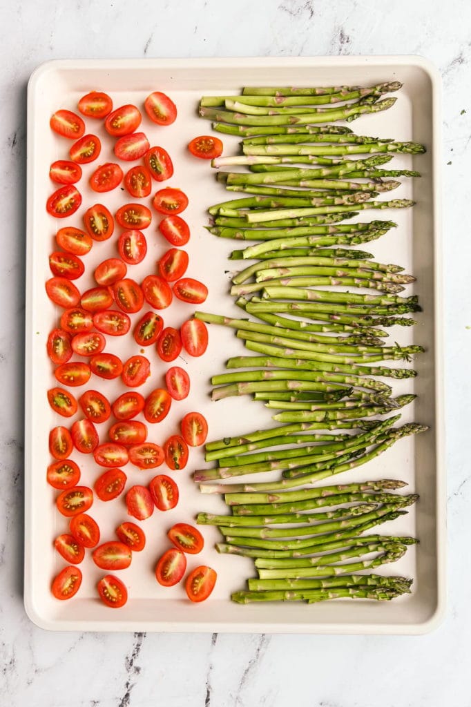 asparagus and grape tomatoes on a sheet pan