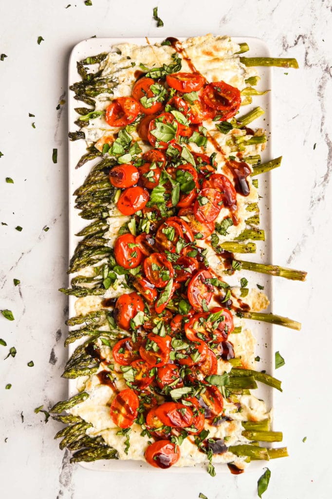 asparagus with melted mozzarella and parmesan cheese topped with roasted grape tomatoes, basil, and balsamic glaze
