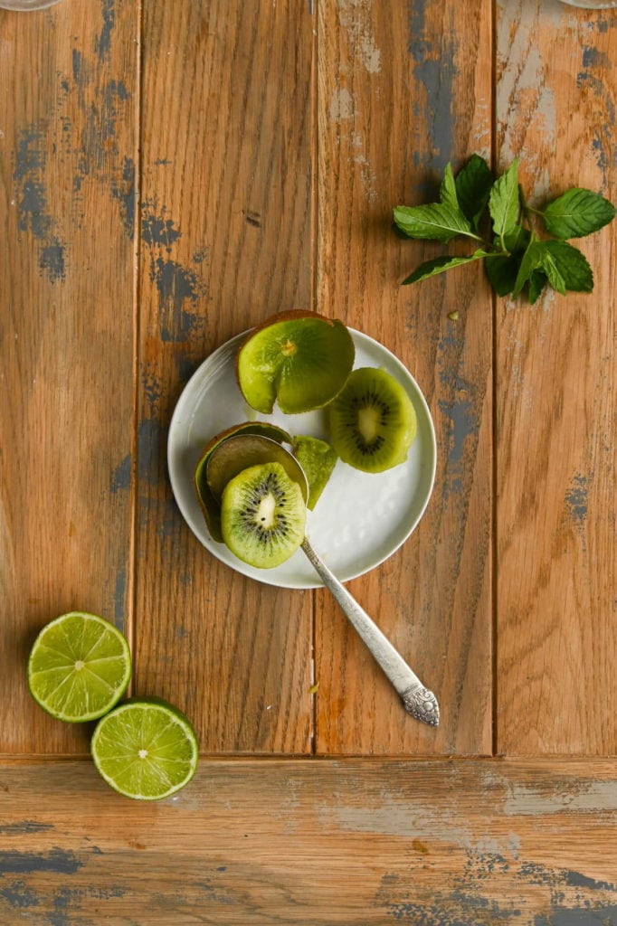 using a spoon to scoop kiwi fruit out of the skin